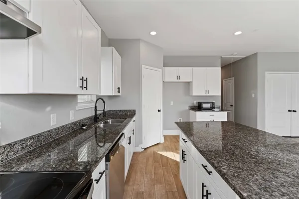 a kitchen with granite countertop stainless steel appliances window a sink and a counter
