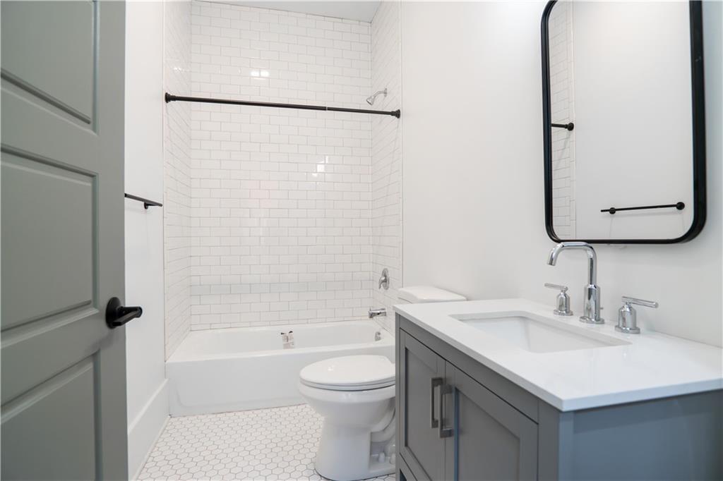 4402 Butler Street Pittsburgh, PA 15201 - Photo 11 of 28 a bathroom with a sink a toilet and a mirror