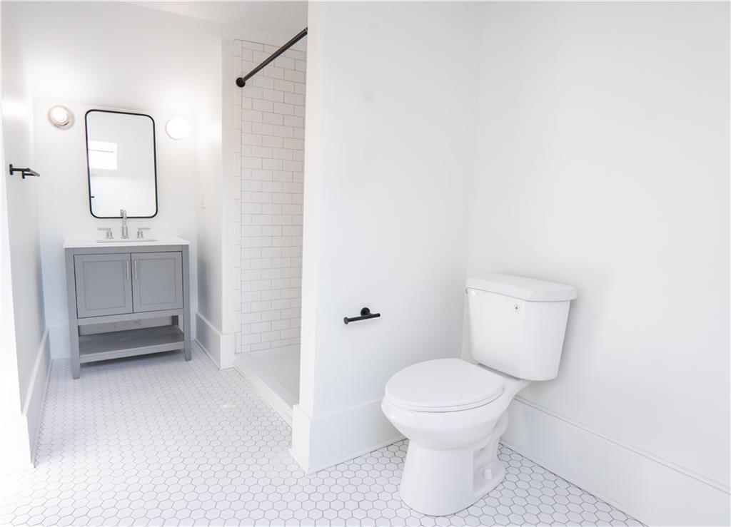 4402 Butler Street Pittsburgh, PA 15201 - Photo 18 of 28 a bathroom with a toilet a sink and mirror