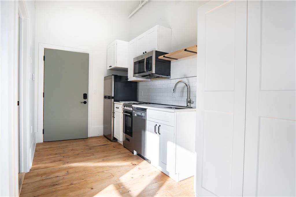4402 Butler Street Pittsburgh, PA 15201 - Photo 19 of 28 a kitchen with stainless steel appliances granite countertop a refrigerator and a sink