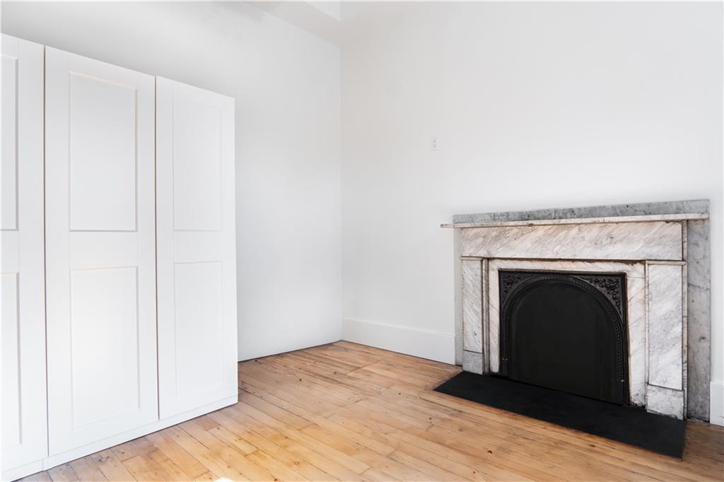 4402 Butler Street Pittsburgh, PA 15201 - Photo 21 of 28 a view of an empty room with wooden floor and a fireplace
