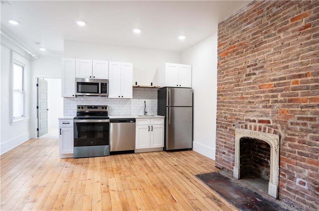 4402 Butler Street Pittsburgh, PA 15201 - Photo 23 of 28 a kitchen with a refrigerator a stove top oven a sink and dishwasher