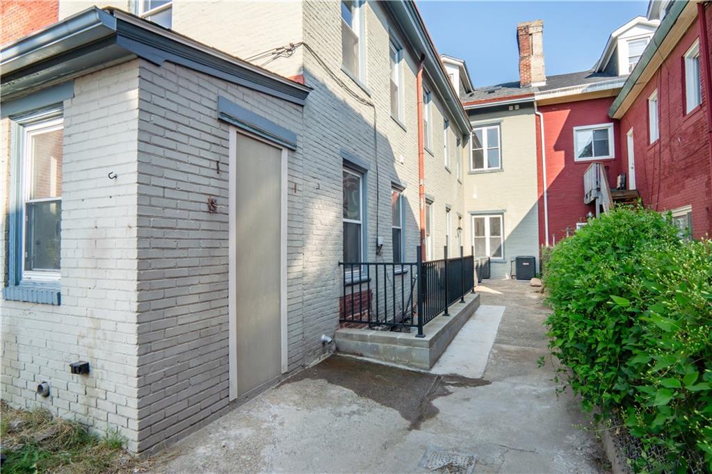4402 Butler Street Pittsburgh, PA 15201 - Photo 27 of 28 a view of a brick house with many windows and flower plants