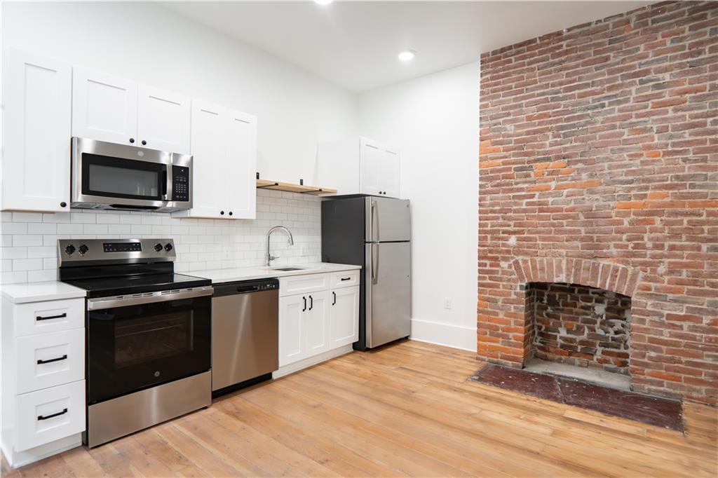 4402 Butler Street Pittsburgh, PA 15201 - Photo 9 of 28 a kitchen with stainless steel appliances a stove sink microwave and cabinets
