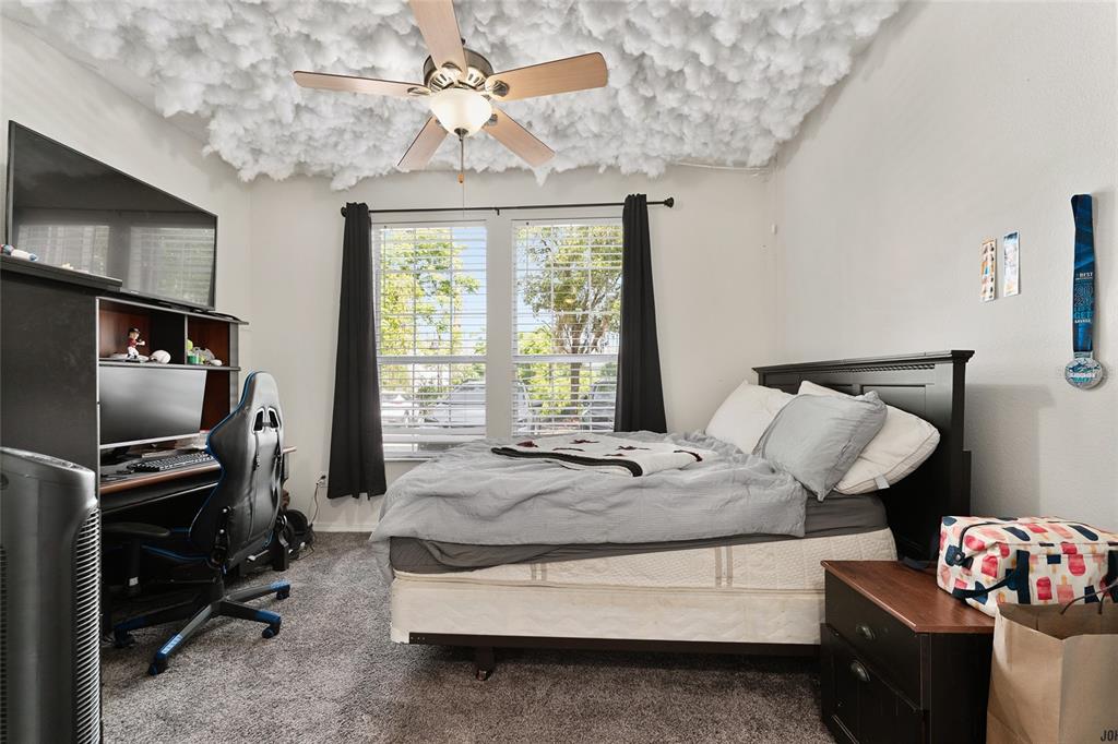 1142 Southwest 9th Road, Unit 103 Gainesville, FL 32601 - Photo 26 of 40 a bedroom with bed and flat tv