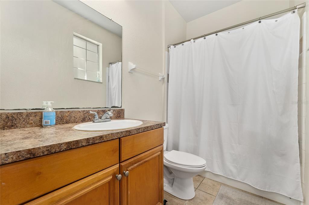 1142 Southwest 9th Road, Unit 103 Gainesville, FL 32601 - Photo 32 of 40 a bathroom with a granite countertop sink and a mirror