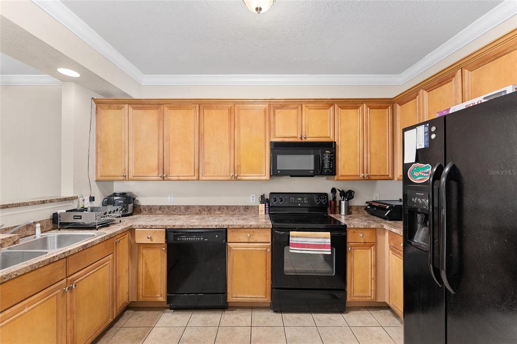 1142 Southwest 9th Road, Unit 103 Gainesville, FL 32601 - Photo 8 of 40 a kitchen with a sink stove top oven and refrigerator
