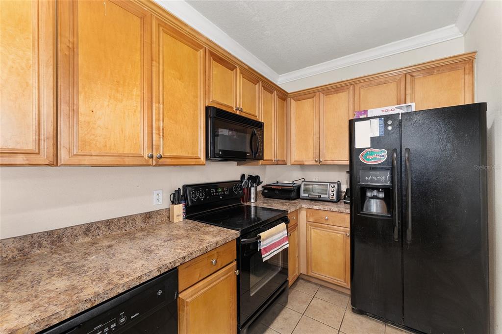 1142 Southwest 9th Road, Unit 103 Gainesville, FL 32601 - Photo 9 of 40 a kitchen with a sink stove and refrigerator
