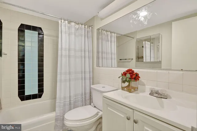 a bathroom with a sink toilet vanity and shower
