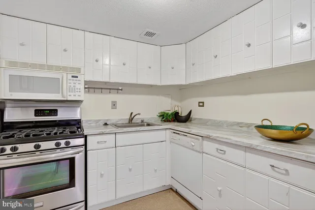 a kitchen with white cabinets and white appliances