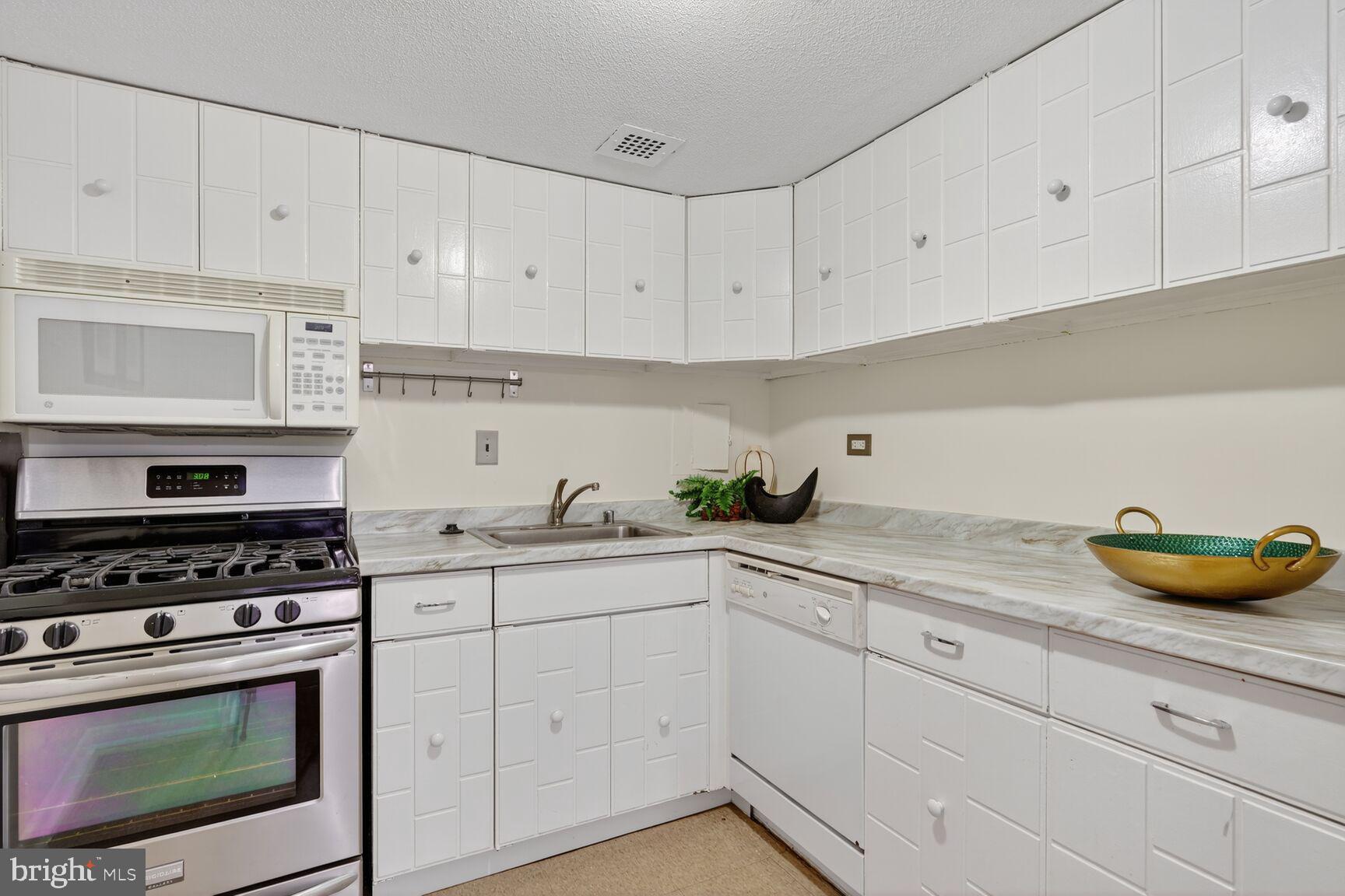 700 7th Street Southwest, Unit 716 Washington, DC 20024 - Photo 9 of 23 a kitchen with white cabinets and white appliances