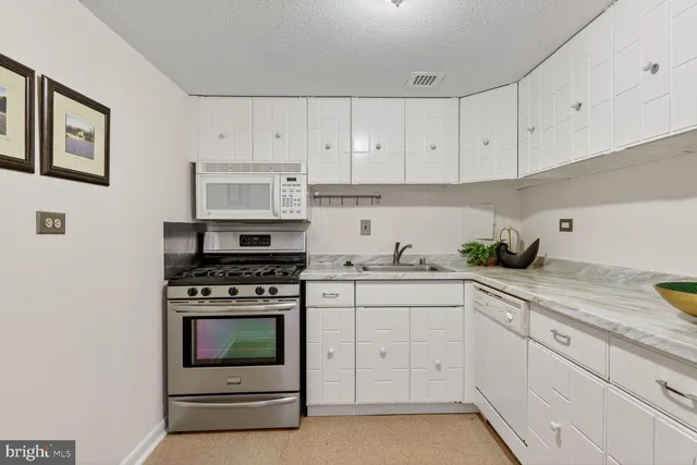 a kitchen with cabinets appliances and a sink