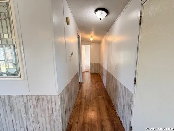 a view of a hallway with wooden floor