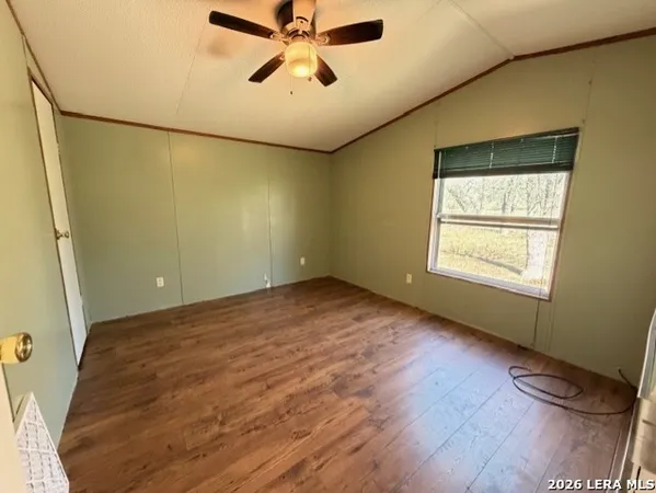 an empty room with windows and fan