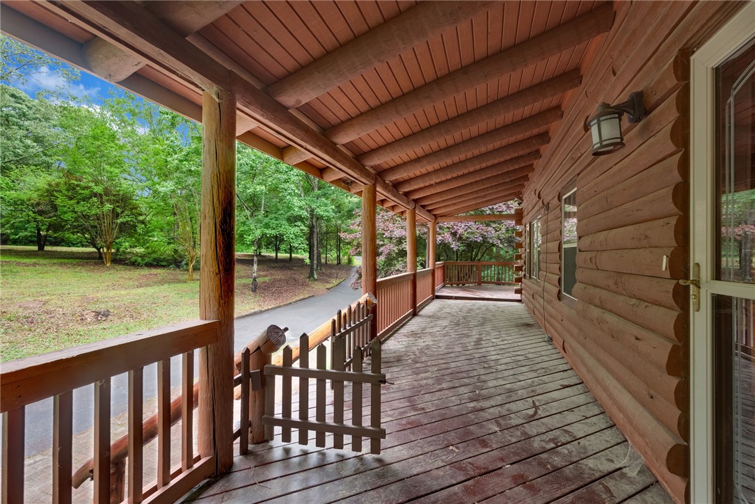 237 Spring Valley Road Liberty, SC 29657 - Photo 49 of 50 A spacious, wrap-around porch offers serene views of lush greenery and mature trees.