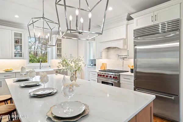 a spacious bathroom with a double vanity sink a mirror a bathtub and next to a window