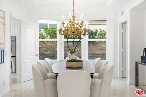 a dining room with chandelier and wooden floor
