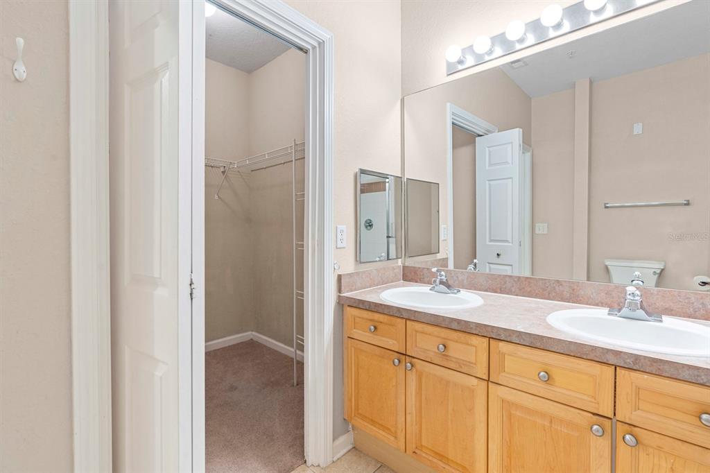 707 Terrace Ridge Circle, Unit 707 Davenport, FL 33896 - Photo 14 of 59 a bathroom with a granite countertop sink and a mirror