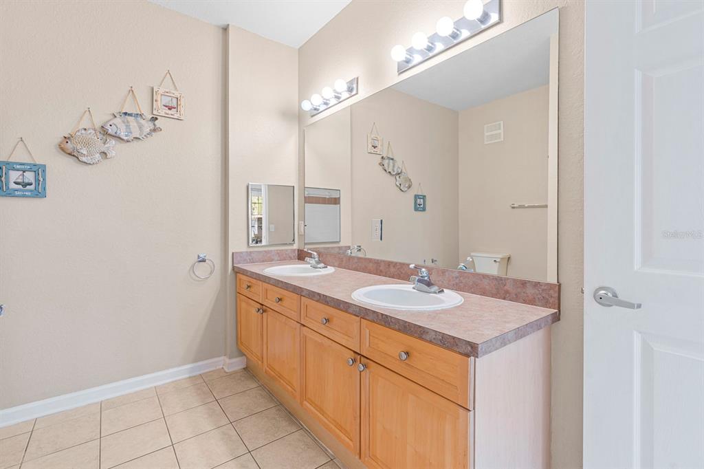 707 Terrace Ridge Circle, Unit 707 Davenport, FL 33896 - Photo 28 of 59 a bathroom with a granite countertop sink and a mirror