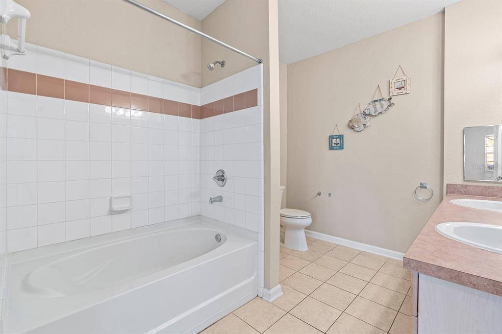 707 Terrace Ridge Circle, Unit 707 Davenport, FL 33896 - Photo 29 of 59 a bathroom with a sink a toilet and a bathtub