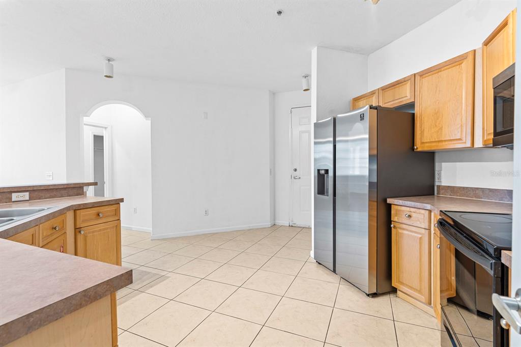 707 Terrace Ridge Circle, Unit 707 Davenport, FL 33896 - Photo 7 of 59 a kitchen with stainless steel appliances granite countertop a refrigerator and a sink