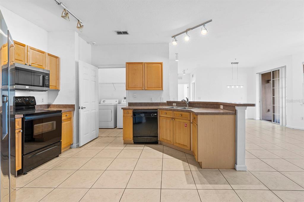 707 Terrace Ridge Circle, Unit 707 Davenport, FL 33896 - Photo 9 of 59 a kitchen with granite countertop a stove top oven and cabinets