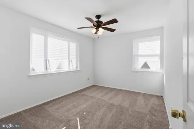 a view of a livingroom with a ceiling fan and window