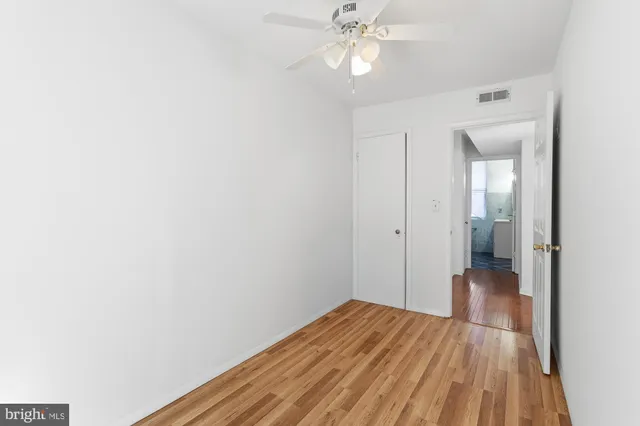 a view of a hallway with wooden floor and closet