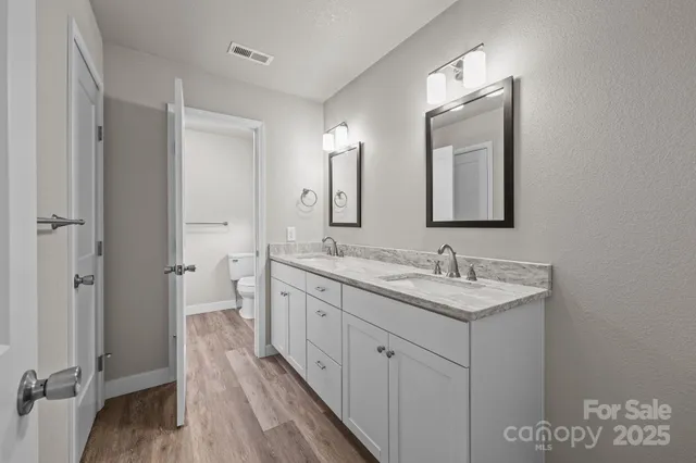a bathroom with double vanity sinks and a mirror
