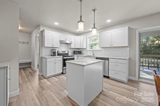 a kitchen with a white wooden cabinets and white stainless steel appliances