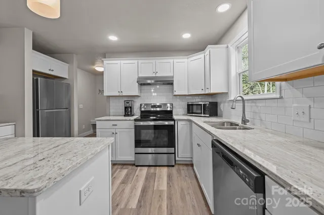 a kitchen with granite countertop a sink stove and refrigerator