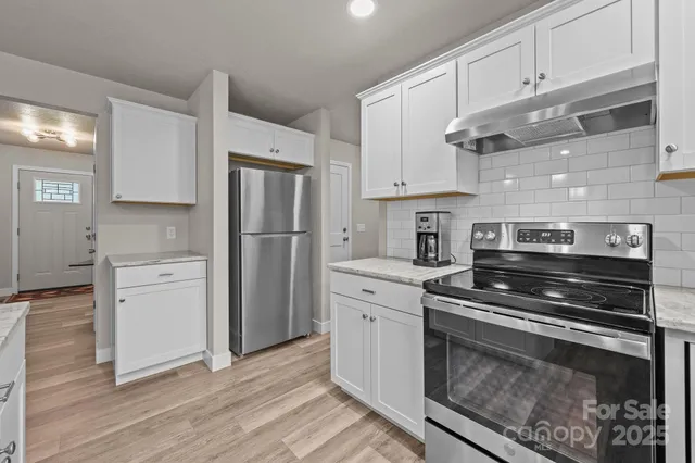 a kitchen with a refrigerator stove and cabinets