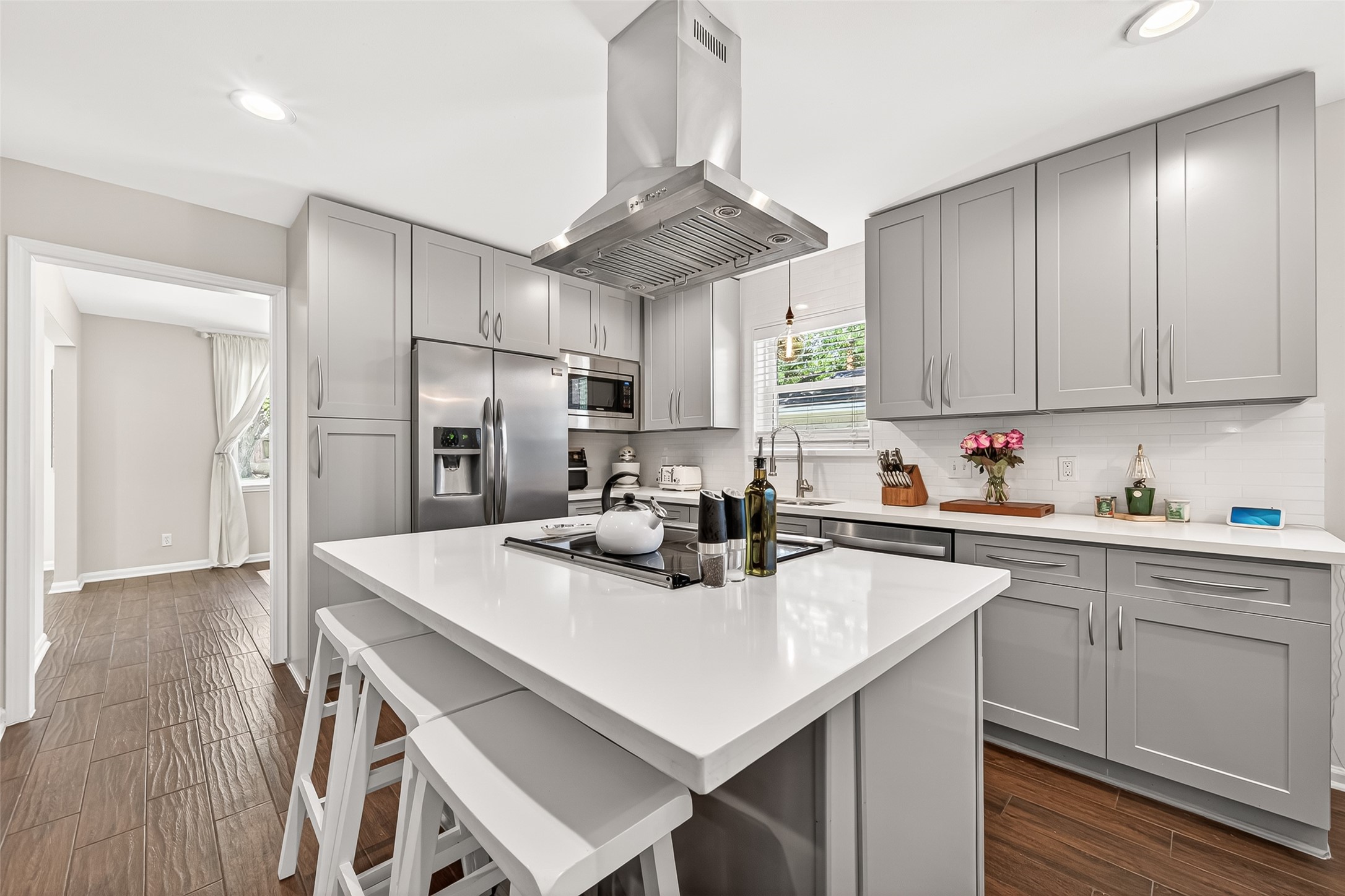 2610 Teague Road Houston, TX 77080 - Photo 22 of 49 This modern kitchen features sleek gray cabinetry, stainless steel appliances, and a central island with bar seating.