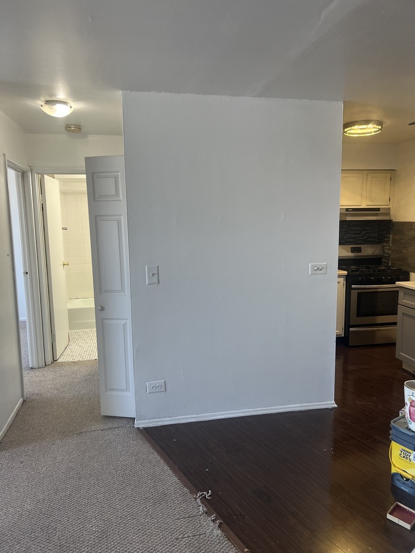 1227 South Harlem Avenue, Unit 512 Berwyn, IL 60402 - Photo 17 of 28 an empty room with wooden floor and way to kitchen