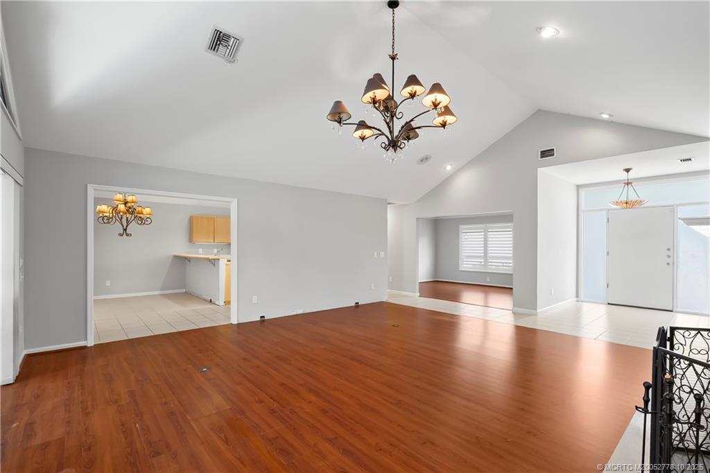101 South Sewalls Point Road Stuart, FL 34996 - Photo 13 of 41 an empty room with wooden floor chandelier and windows