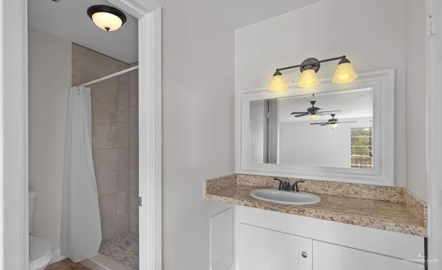 a bathroom with a granite countertop sink and a mirror