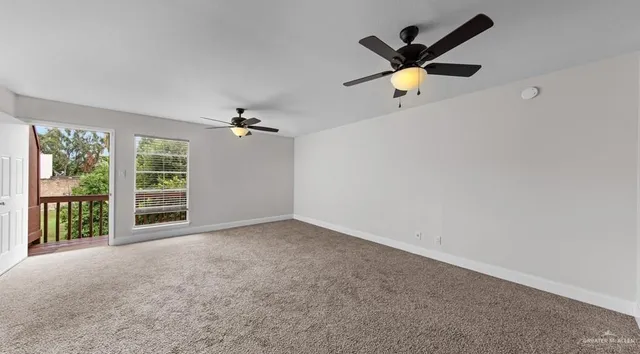 an empty room with a ceiling fan and window