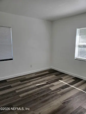 a view of a room with wooden floor and window