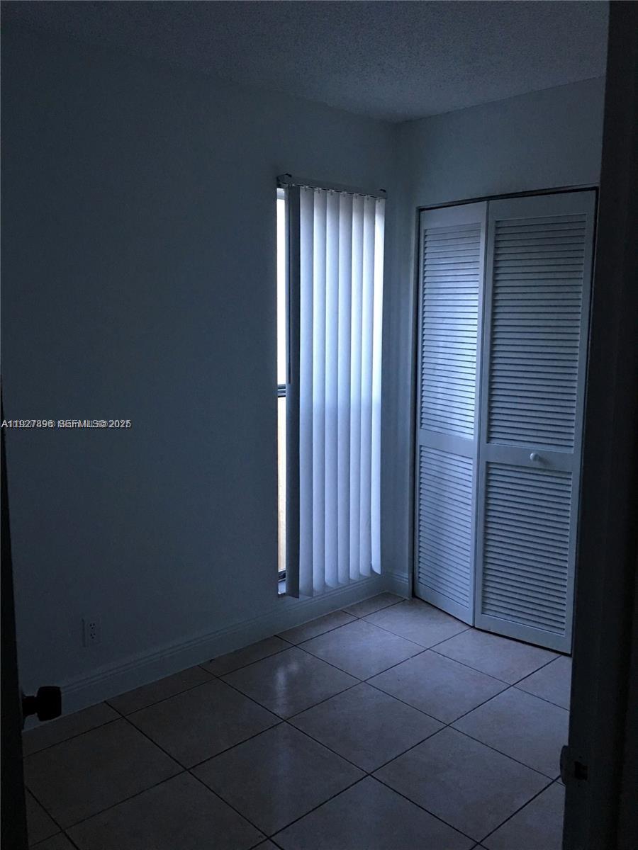 4431 Treehouse Lane, Unit H Tamarac, FL 33319 - Photo 7 of 10 an empty room with windows