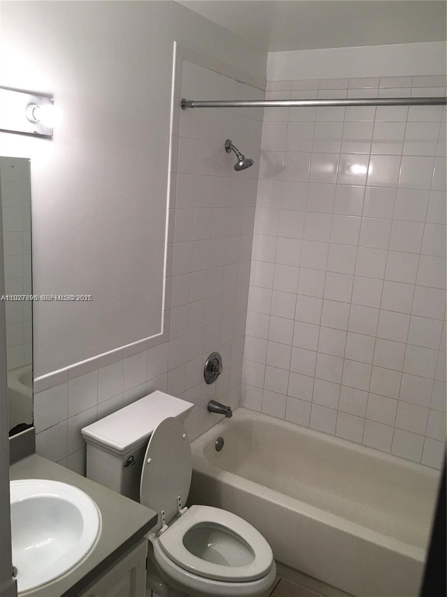 4431 Treehouse Lane, Unit H Tamarac, FL 33319 - Photo 8 of 10 a bathroom with a sink toilet and shower