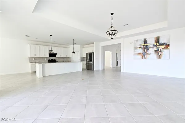 a view of a kitchen with kitchen island stainless steel appliances refrigerator stove microwave and cabinets