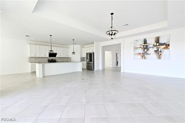 a view of a kitchen with kitchen island stainless steel appliances refrigerator stove microwave and cabinets