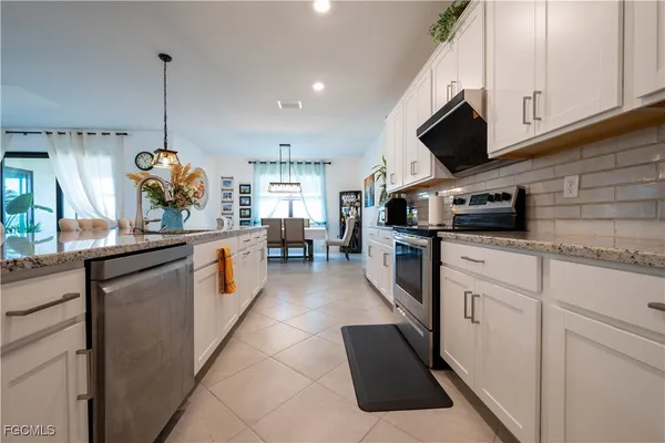 a kitchen with stainless steel appliances kitchen island granite countertop a sink a stove and a microwave