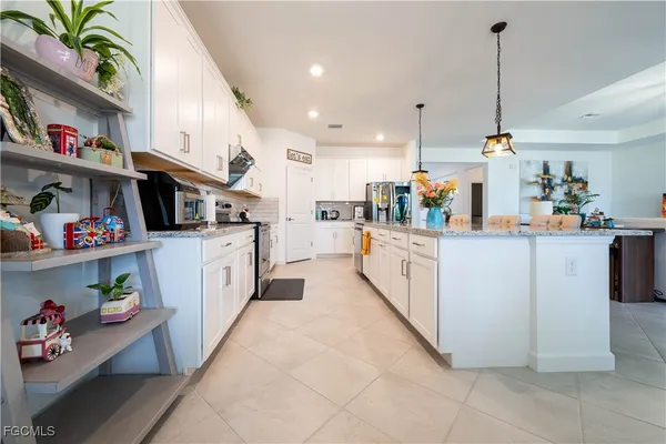 a kitchen with kitchen island and white cabinets