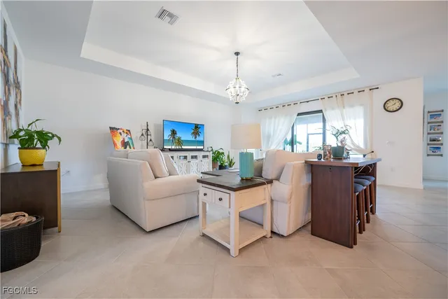 a living room with furniture and a chandelier