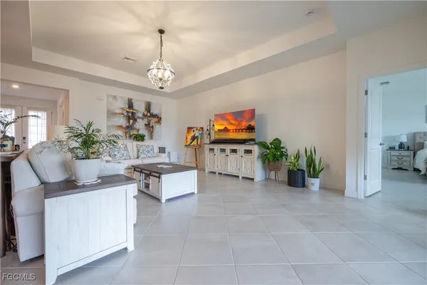 a living room with furniture a chandelier and a flat screen tv
