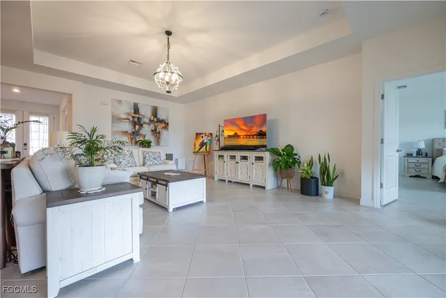 a living room with furniture a chandelier and a flat screen tv