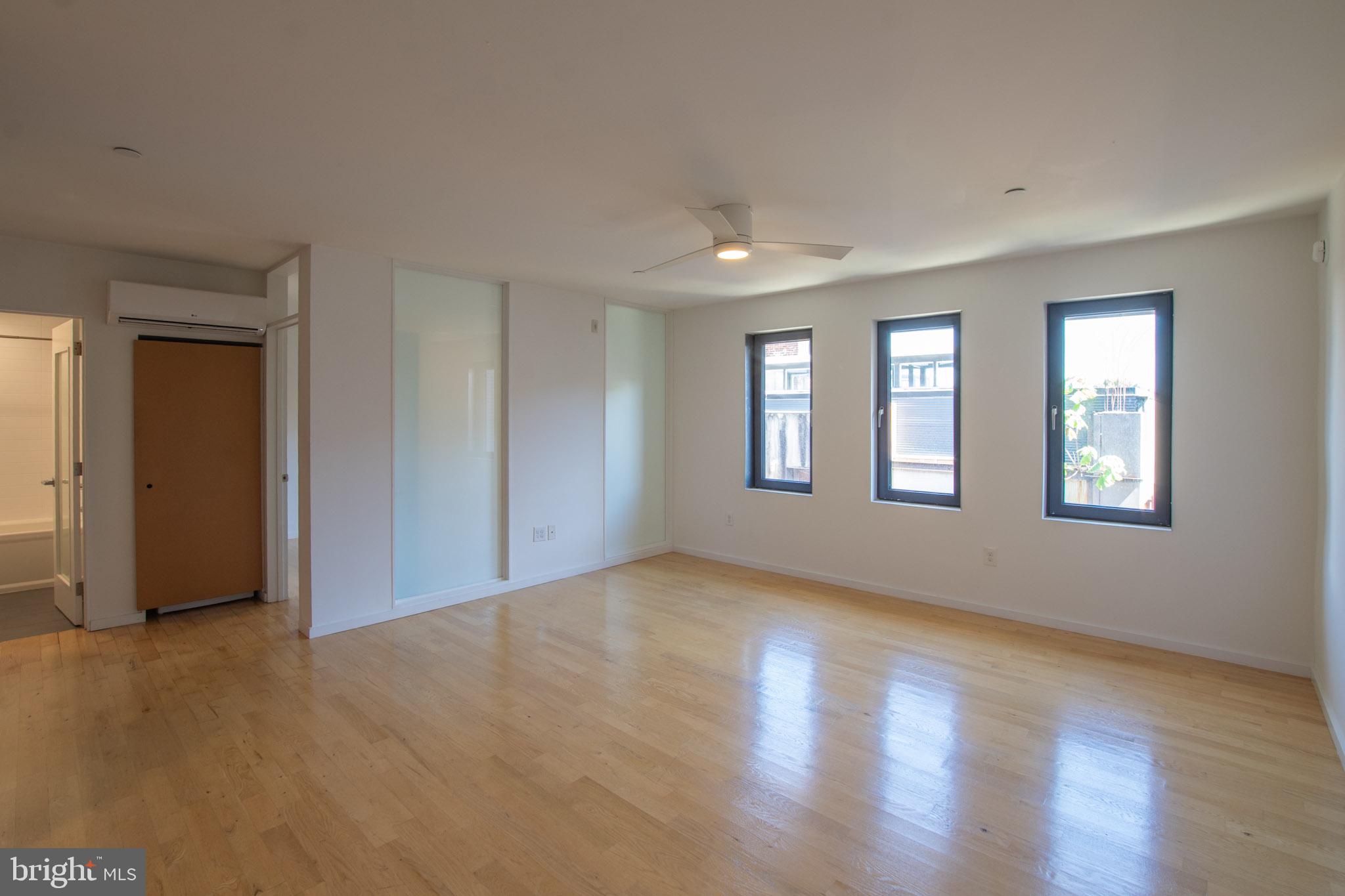 152 West Laurel Street, Unit 303 Philadelphia, PA 19123 - Photo 12 of 36 a view of an empty room with window and wooden floor
