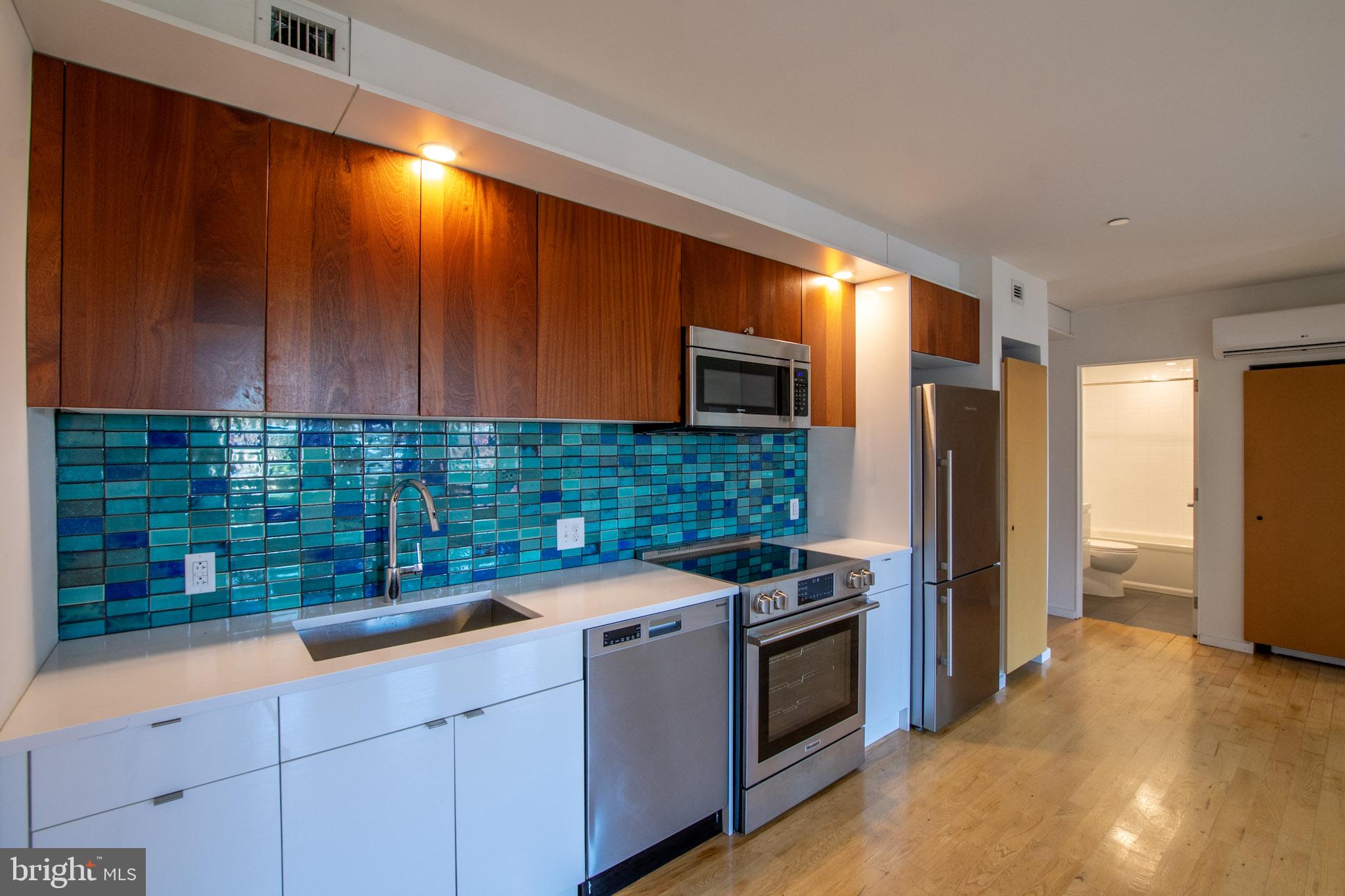 152 West Laurel Street, Unit 303 Philadelphia, PA 19123 - Photo 6 of 36 a kitchen with stainless steel appliances granite countertop a refrigerator and a sink