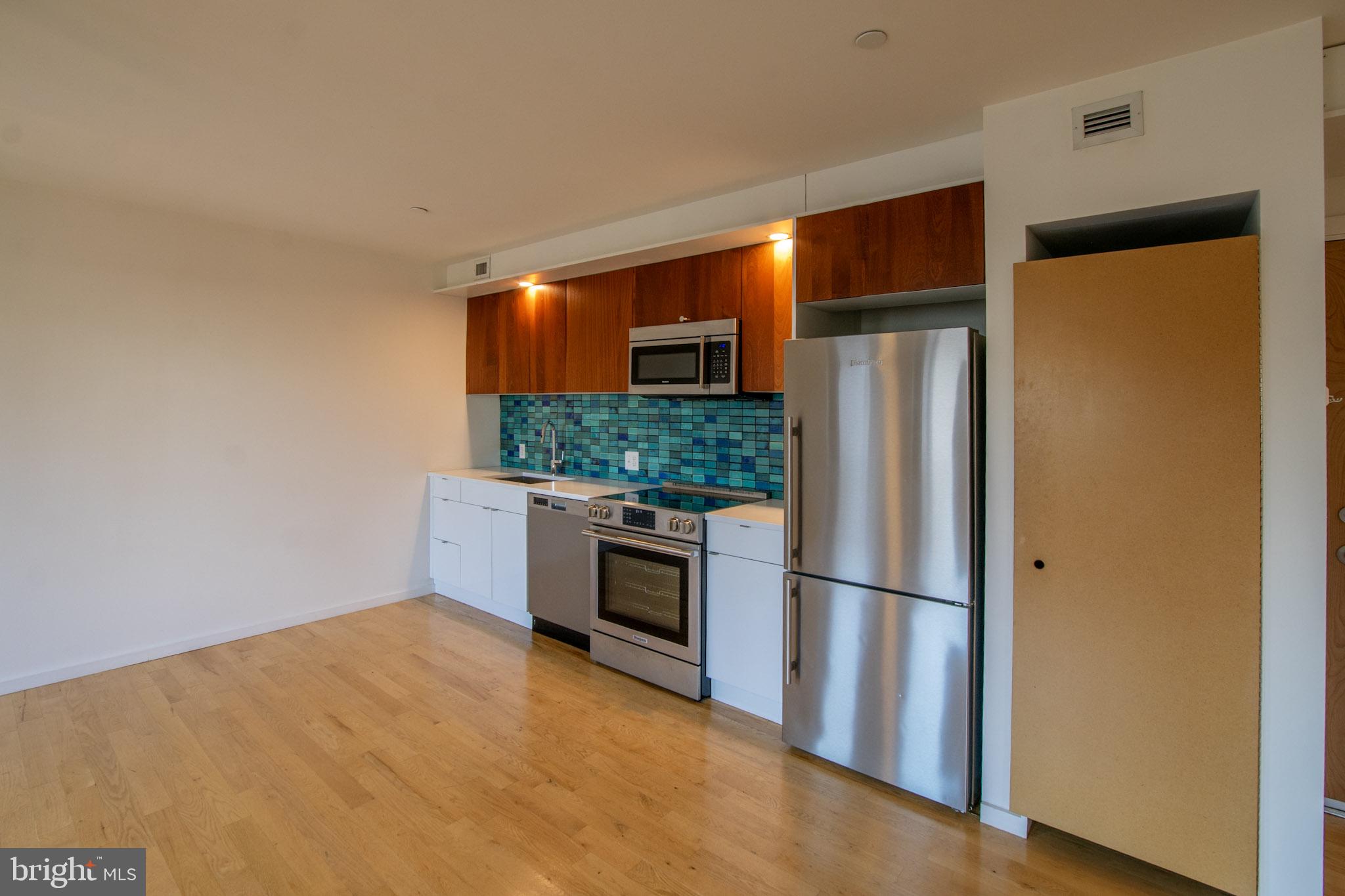 152 West Laurel Street, Unit 303 Philadelphia, PA 19123 - Photo 7 of 36 a kitchen with stainless steel appliances a refrigerator and a stove top oven